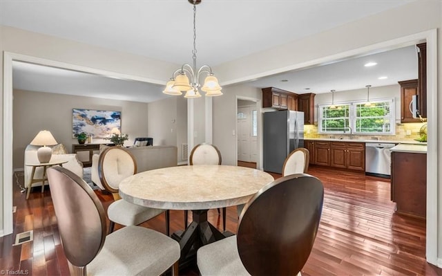 dining area featuring a chandelier, dark wood-type flooring, and recessed lighting
