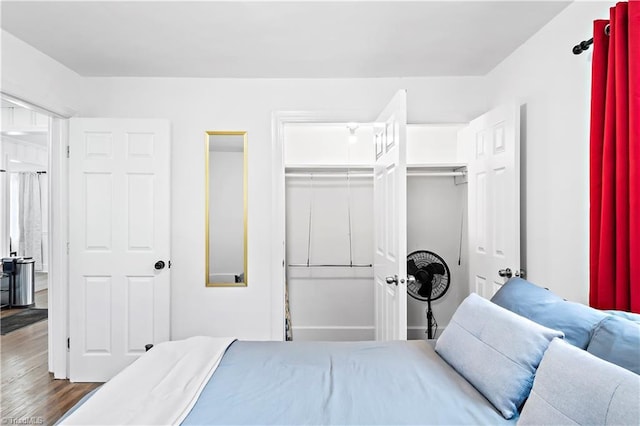 bedroom with dark wood-type flooring and a closet