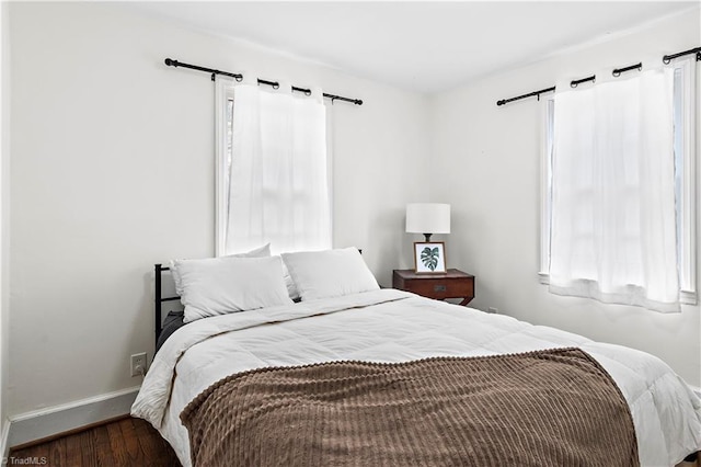 bedroom featuring dark wood-type flooring and a barn door