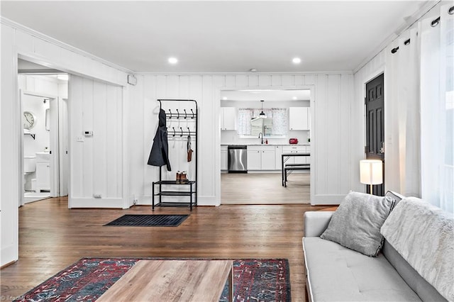 living room with crown molding, sink, and hardwood / wood-style floors