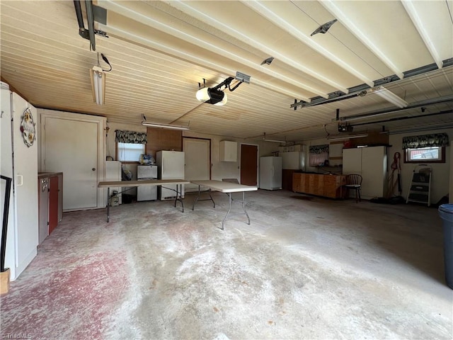 garage with freestanding refrigerator and a garage door opener