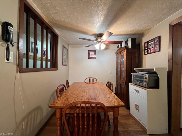 dining space featuring a textured ceiling, ceiling fan, wood finished floors, and a toaster