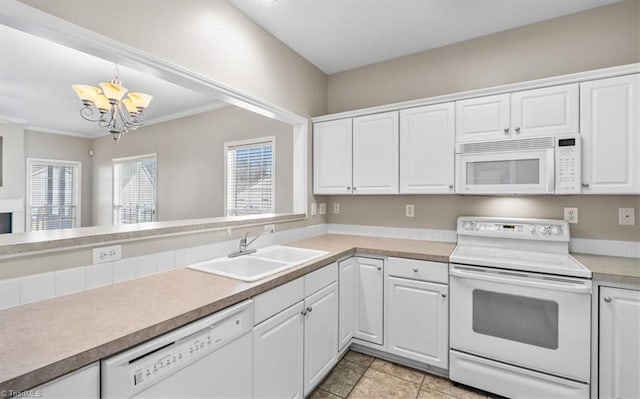 kitchen featuring decorative light fixtures, sink, white appliances, and white cabinets