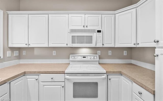 kitchen featuring white cabinets and white appliances