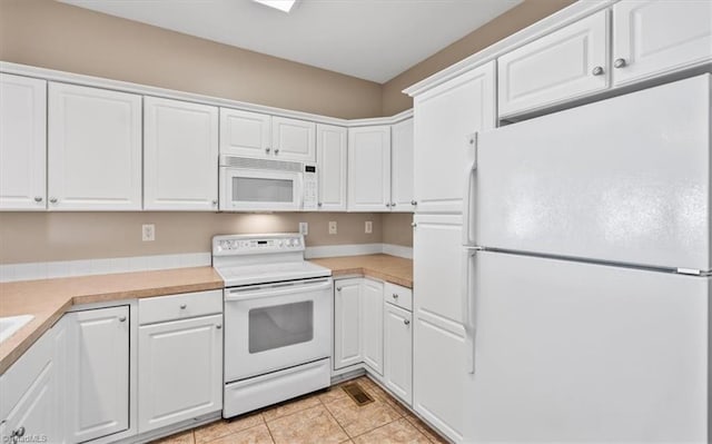 kitchen featuring white cabinetry, white appliances, and light tile patterned flooring