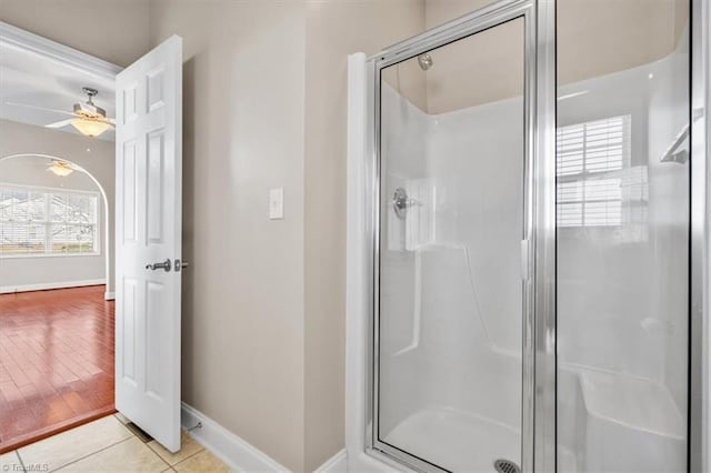 bathroom with ceiling fan, an enclosed shower, and tile patterned flooring