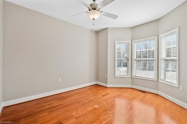 empty room with ceiling fan and light hardwood / wood-style flooring