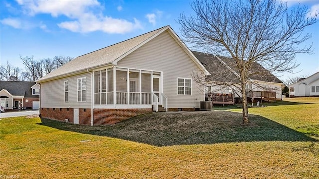 exterior space with cooling unit, a lawn, and a sunroom