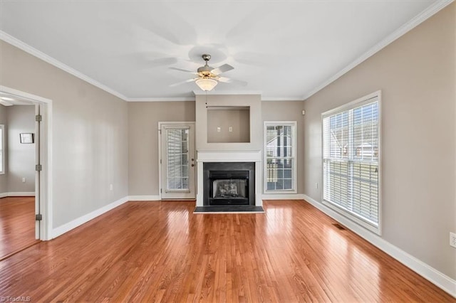 unfurnished living room featuring ceiling fan, hardwood / wood-style floors, and crown molding