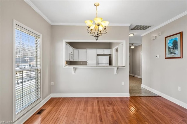 unfurnished dining area featuring crown molding, light hardwood / wood-style floors, a chandelier, and a wealth of natural light