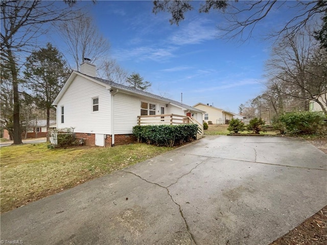 view of property exterior with crawl space, a lawn, and a chimney