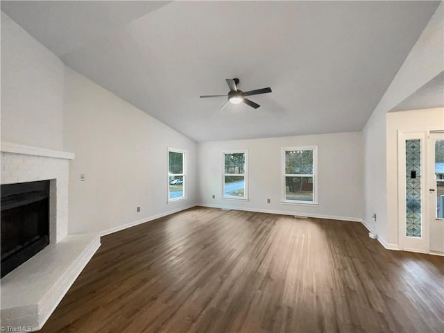 unfurnished living room with a ceiling fan, baseboards, dark wood finished floors, a fireplace, and vaulted ceiling