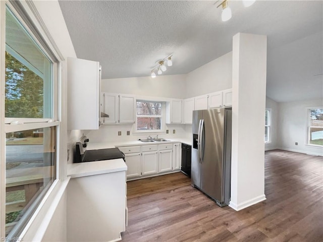 kitchen with stainless steel fridge with ice dispenser, dishwasher, electric range oven, vaulted ceiling, and a sink