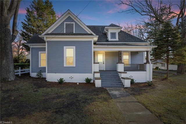 bungalow-style house featuring a yard and covered porch