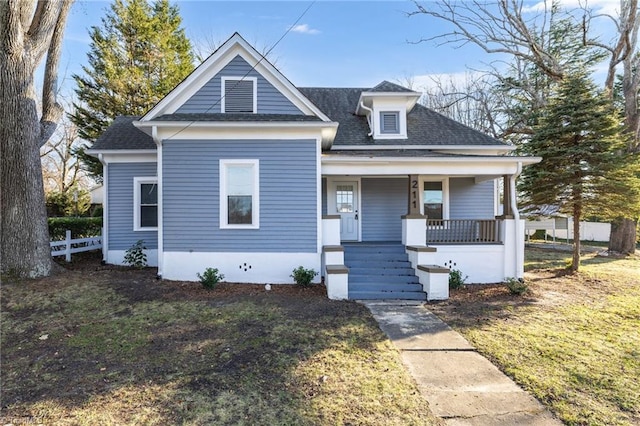 bungalow with a front yard and covered porch