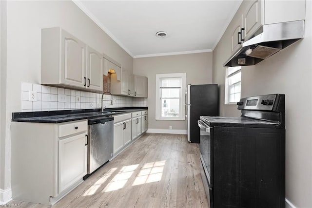 kitchen with a sink, under cabinet range hood, stainless steel appliances, visible vents, and ornamental molding