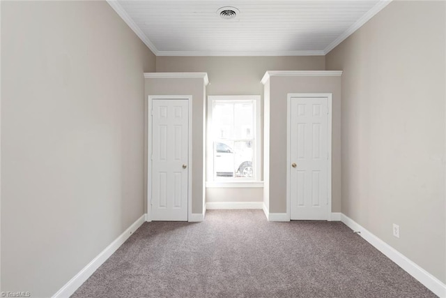unfurnished bedroom featuring baseboards, carpet flooring, visible vents, and crown molding