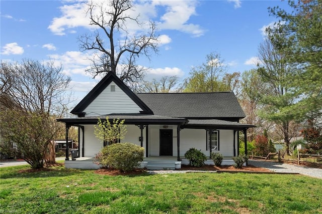 view of front of home with covered porch, a front yard, and a shingled roof