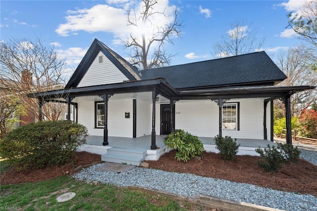 view of front of home featuring covered porch and a shingled roof