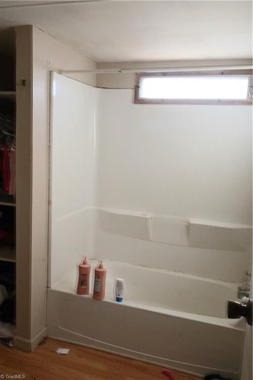 bathroom featuring bathtub / shower combination and wood-type flooring