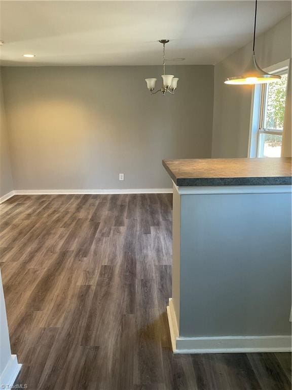 interior space with pendant lighting, dark hardwood / wood-style floors, and a notable chandelier