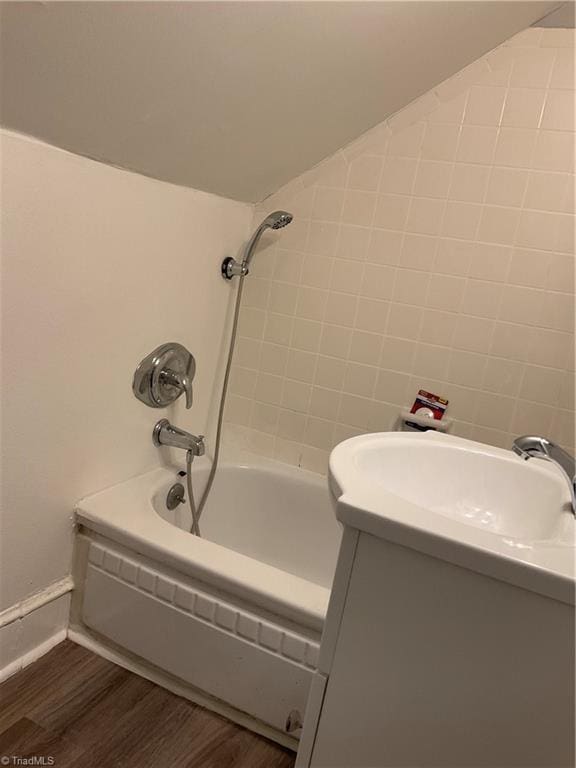 bathroom featuring hardwood / wood-style floors, vanity, and shower / bathtub combination