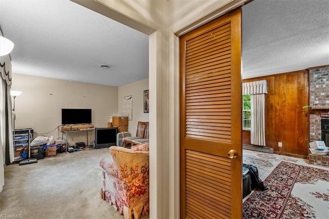 318 Sedalia Rd, Gibsonville, NC 27249 - living room with a textured ceiling, carpet flooring, a baseboard radiator, and a brick fireplace