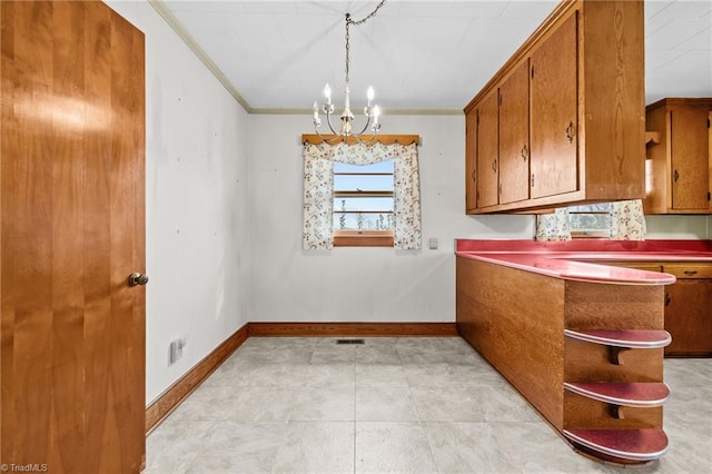 kitchen with decorative light fixtures, an inviting chandelier, and crown molding