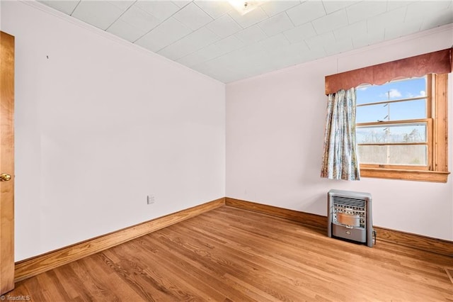 unfurnished room featuring heating unit and light wood-type flooring