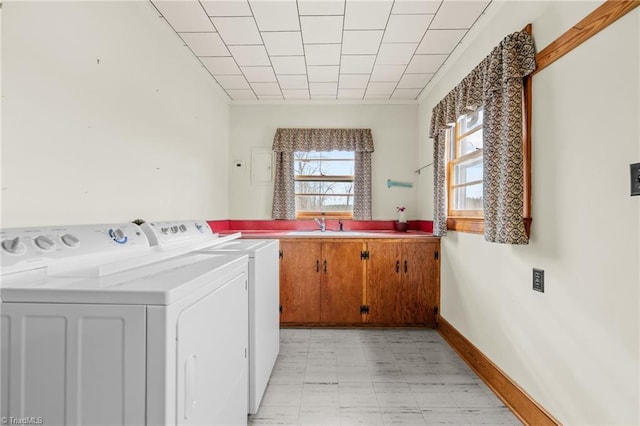 laundry room featuring sink, washer and dryer, and cabinets