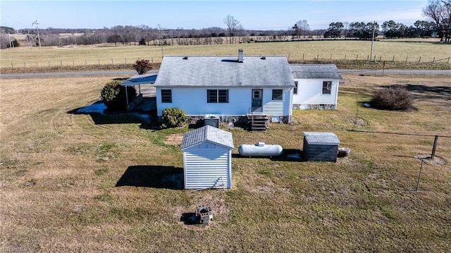 exterior space with a lawn, a storage shed, and a rural view