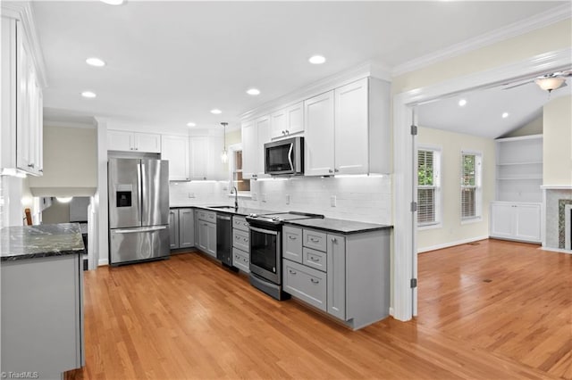 1022 Willowlake Rd, Winston-Salem, NC 27106 - kitchen featuring appliances with stainless steel finishes, gray cabinets, light wood-style flooring, crown molding, and tasteful backsplash