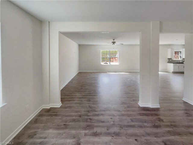 unfurnished dining area with baseboards, wood finished floors, and ceiling fan