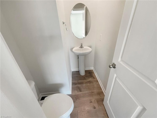 bathroom featuring wood finished floors, toilet, and baseboards