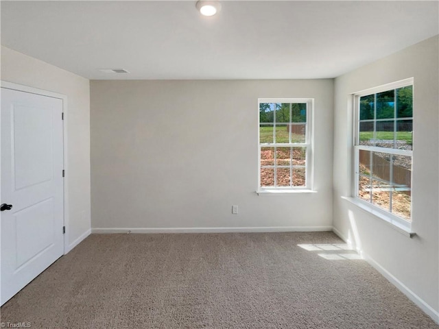 carpeted empty room with baseboards and visible vents