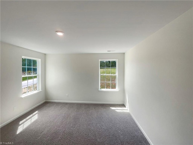 empty room featuring carpet and baseboards