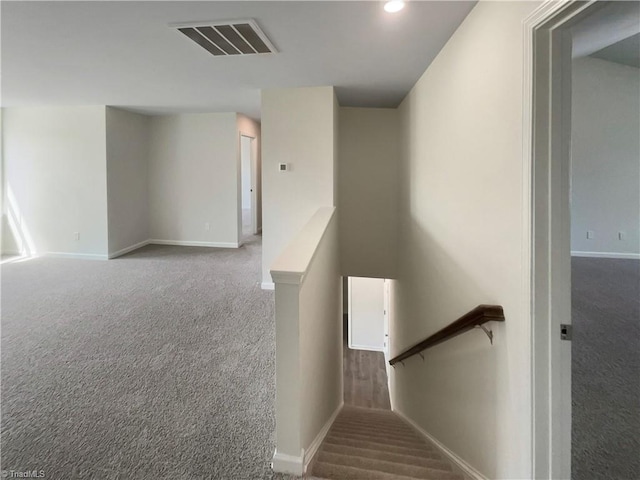 stairway featuring visible vents, baseboards, and carpet floors