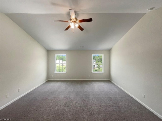 carpeted empty room with a ceiling fan, visible vents, lofted ceiling, and baseboards
