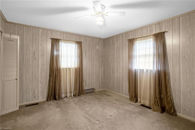 unfurnished room featuring ceiling fan, light colored carpet, and a baseboard radiator