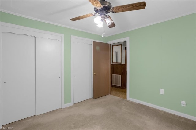 unfurnished bedroom with crown molding, light carpet, and ceiling fan