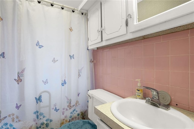 bathroom with tasteful backsplash, tile walls, vanity, toilet, and a shower with curtain