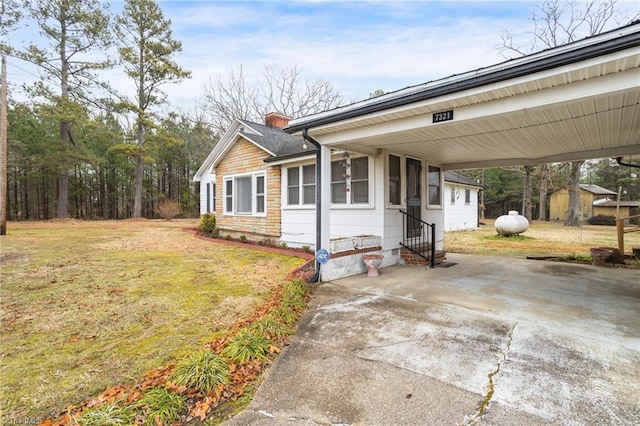 view of front facade with a front lawn and a carport