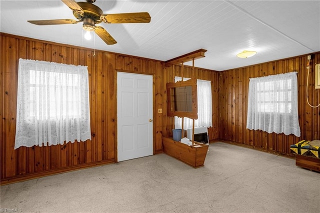 interior space with a wealth of natural light, light colored carpet, and ceiling fan