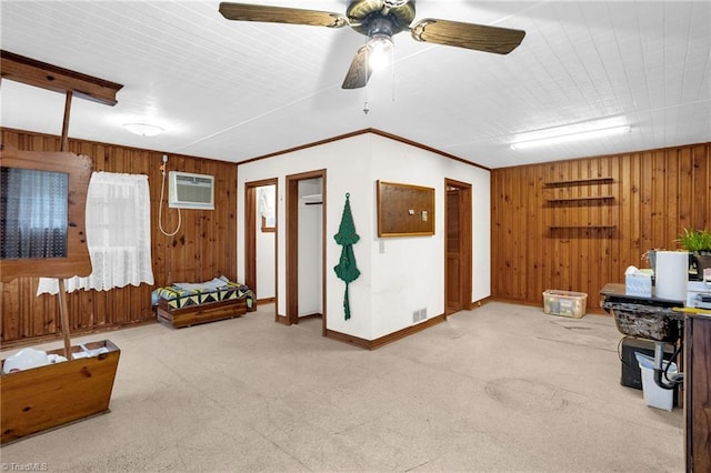 interior space featuring an AC wall unit, wood walls, ceiling fan, crown molding, and light carpet