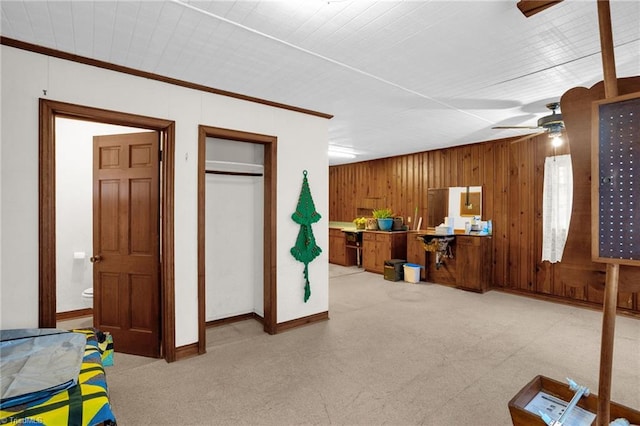 interior space featuring connected bathroom, crown molding, a closet, and ceiling fan