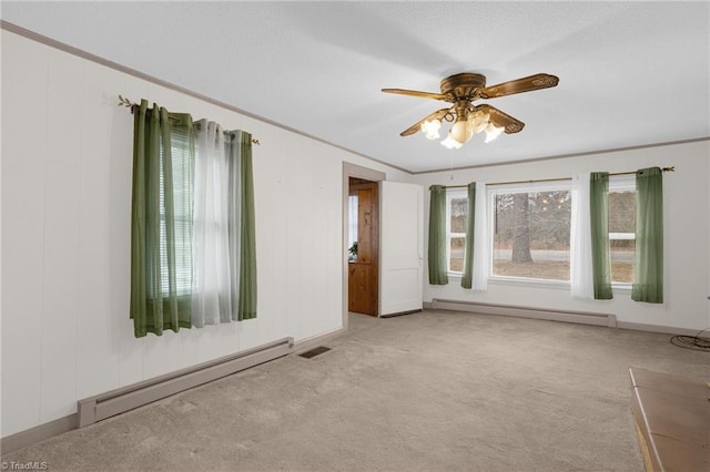 spare room featuring a wealth of natural light, ornamental molding, and baseboard heating