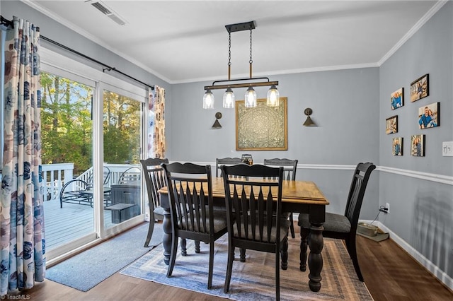 dining room with hardwood / wood-style floors and ornamental molding