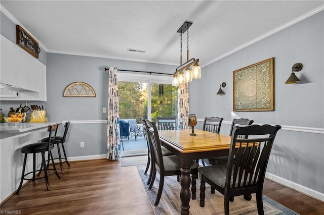 dining area featuring dark hardwood / wood-style floors and crown molding