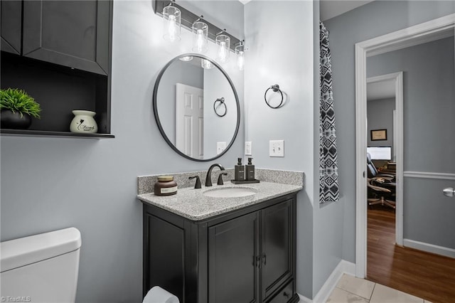 bathroom featuring wood-type flooring, toilet, and vanity