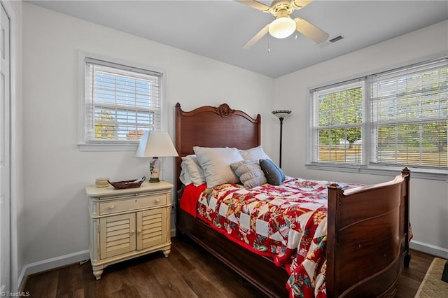 bedroom with ceiling fan, multiple windows, and dark hardwood / wood-style floors